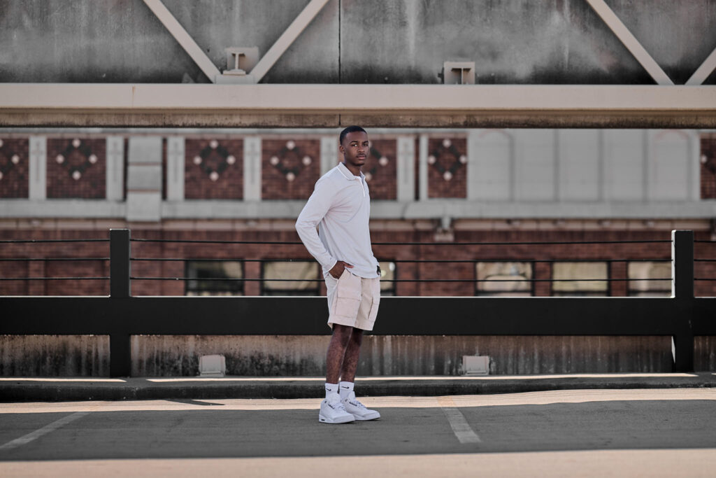 senior guy on top of a parking garage with cool brick in the background