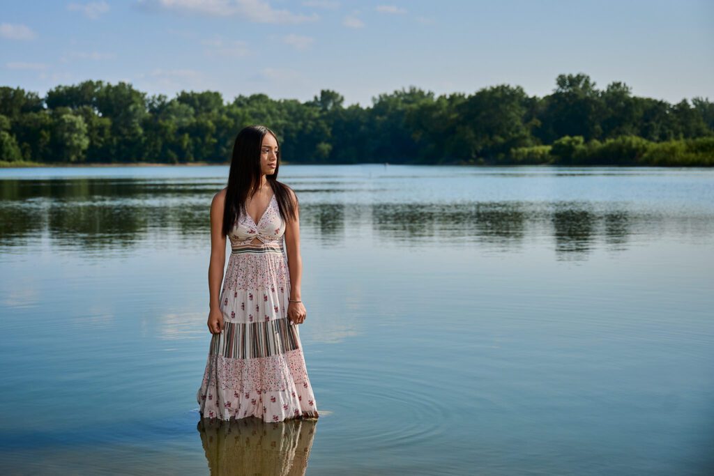 Senior pictures at Saylorville Lake in Ankeny with white dress in the water